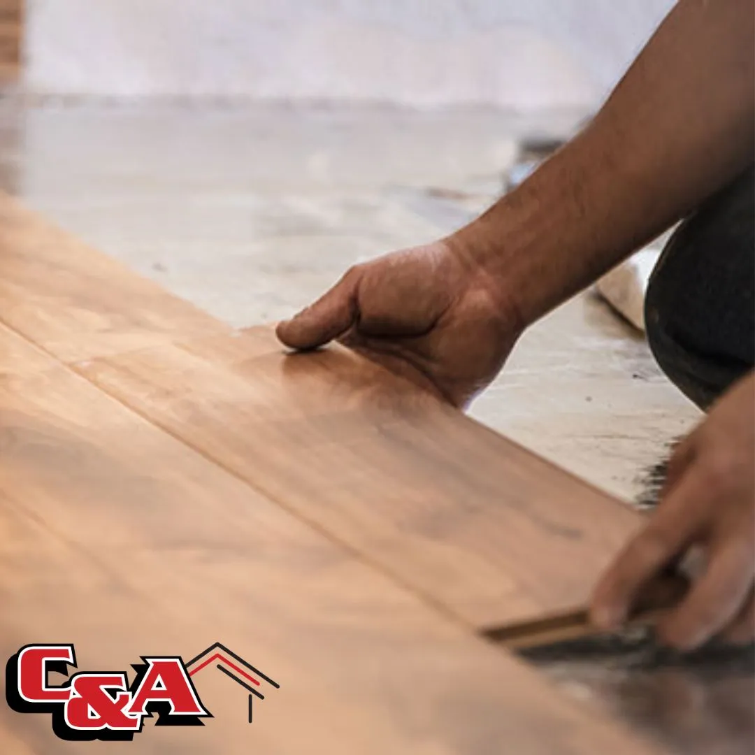 Professional flooring installer carefully placing hardwood planks