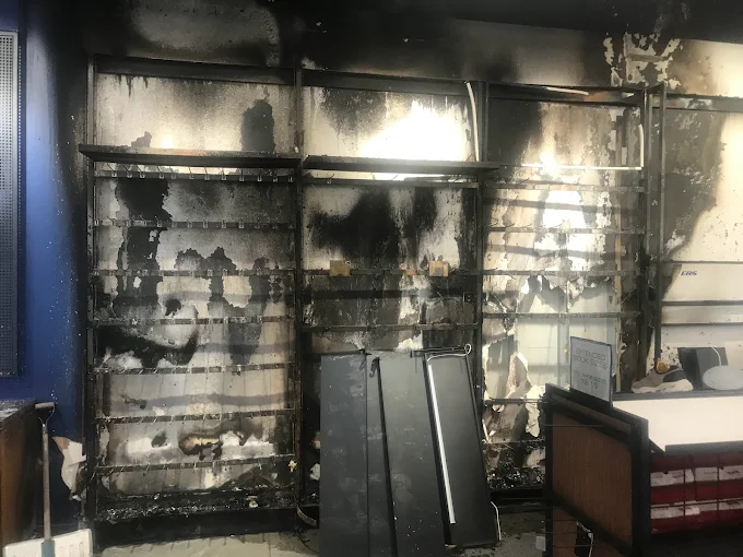 Severe fire damage to kitchen cabinets and appliances showing extent of fire restoration needed