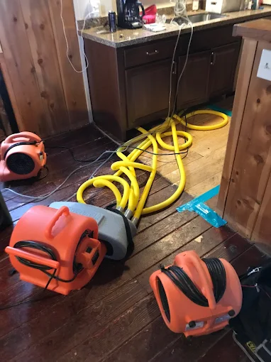 Water restoration equipment with professional drying hoses deployed in Oklahoma basement water damage