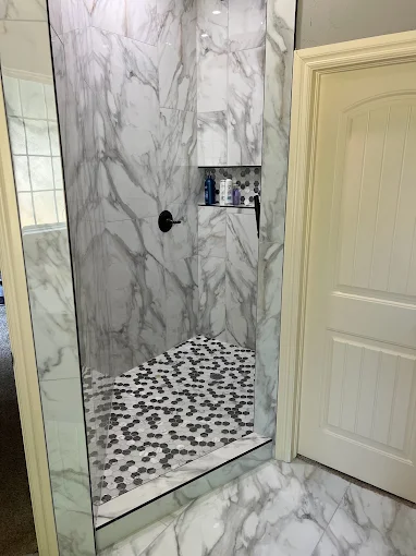Marble-look shower with hex tile floor by C&A Roofing & Construction