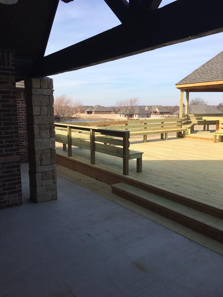 Large deck with built-in seating and railings overlooking residential area