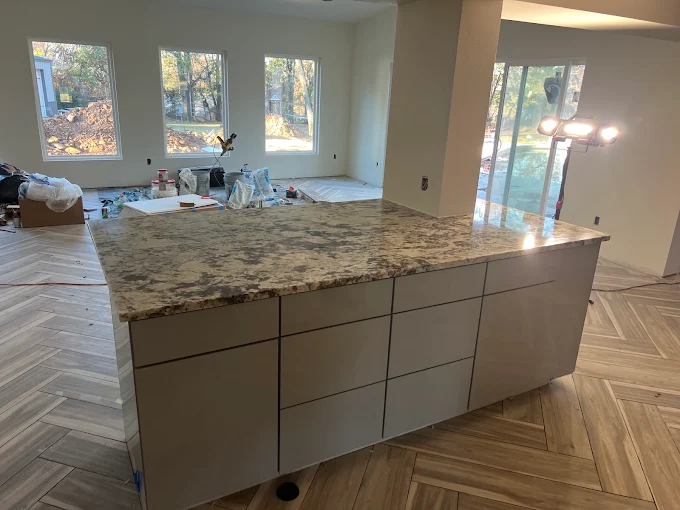 Kitchen island installation with granite countertop and herringbone flooring